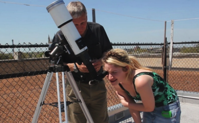 A photo of a student looking in a telescope